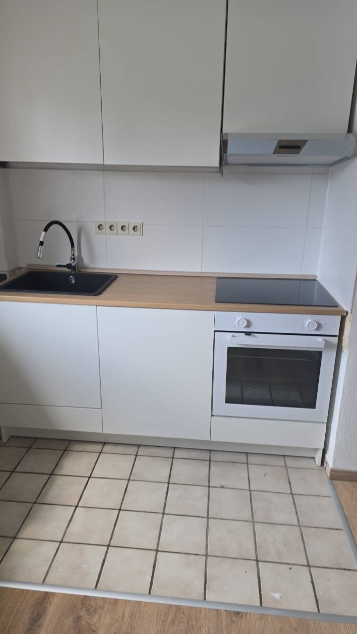 Montierte Küchenzeile mit Spüle, Kochfeld, Backofen und Hängeschränken